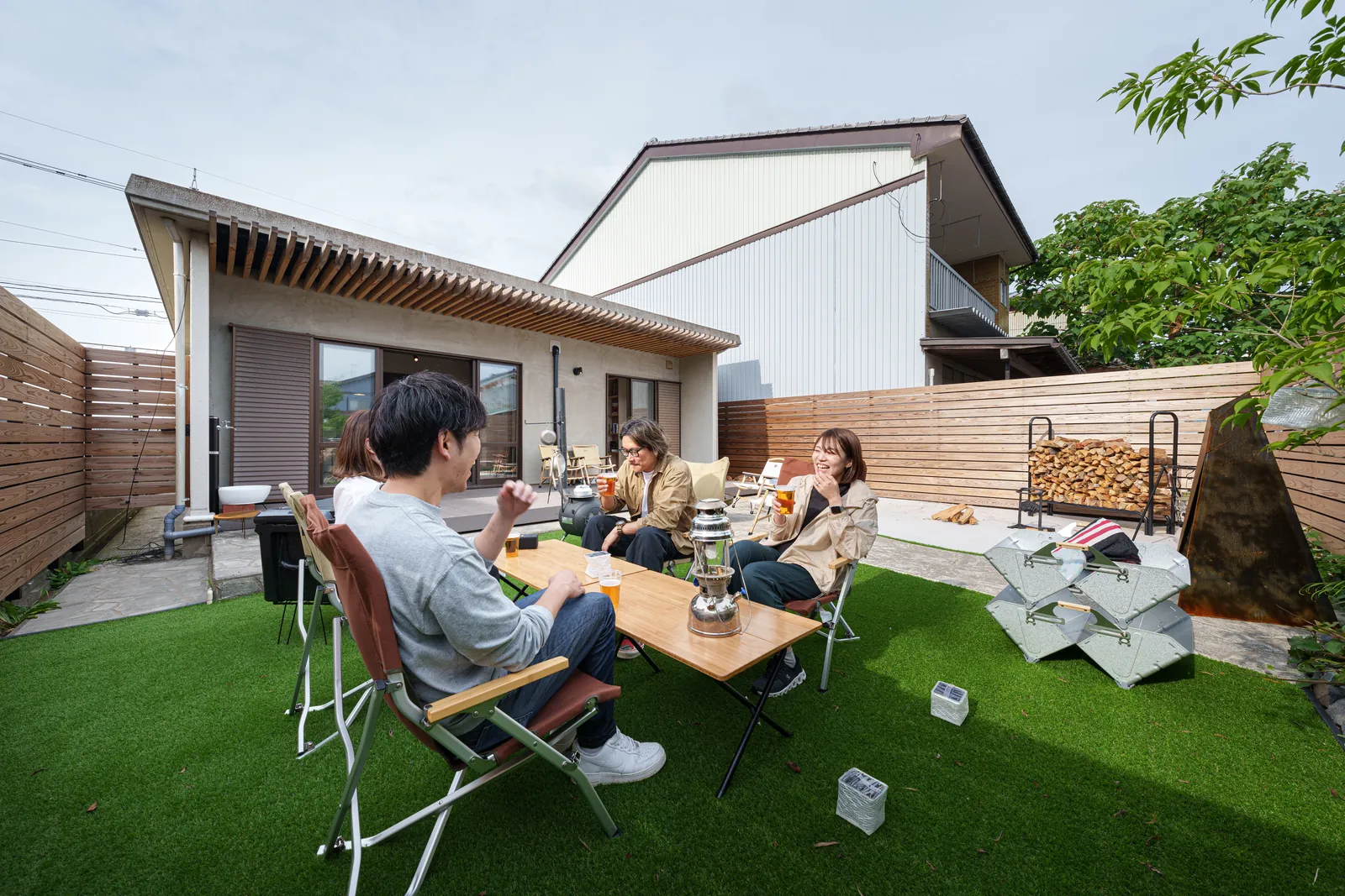 庭でくつろぐ人たちと平屋の住まい